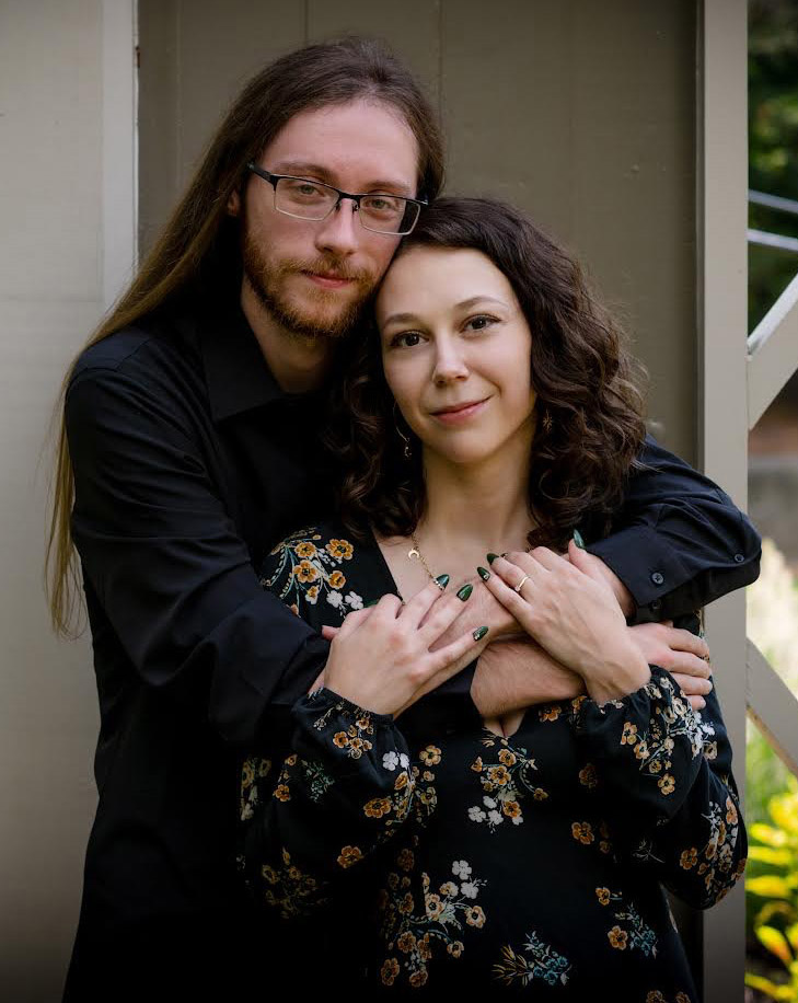Groom hugging bride from behind
